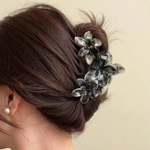 Plumeria hair claw clip with marble ink pattern in black and white on dark hair