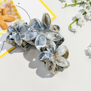 Detail of marble pattern frangipani hair claw clip made of acetic acid material