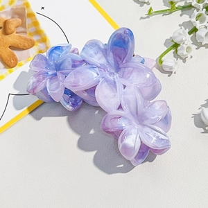 Close-up of marble-patterned floral hair claw clip in purple and blue gradient
