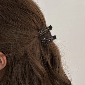 Elegante Haarspangen mit bunten Strasssteinen auf gewelltem braunem Haar gestylt