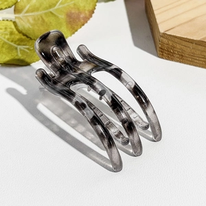 Detailansicht der transparenten Haarklammer mit Marmormuster und elegantem Zahndesign