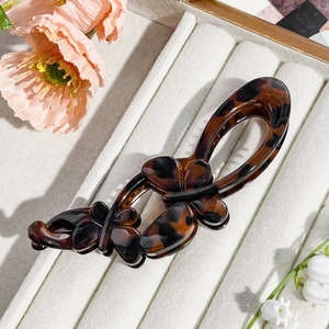 Macro shot of tortoiseshell butterfly hair clip on velvet display box with floral accents