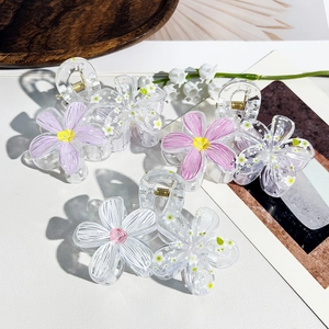 Detail of floral hair claws in resin with colorful petals and internal flower patterns