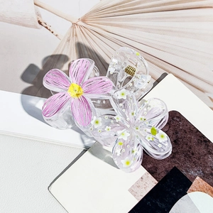 Detailed view of floral hair claws with resin texture and metallic spring clip