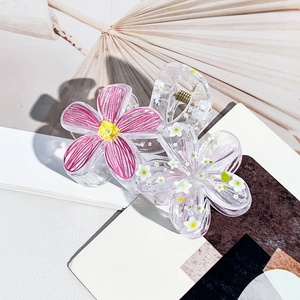 Detail view of floral hair claws with pink graffiti petals and white floral patterns
