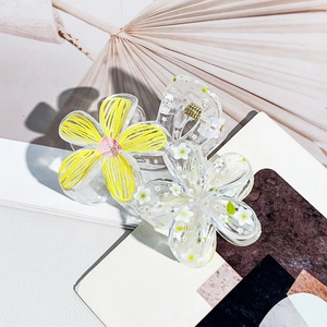 Detail of transparent floral hair claw with yellow flower and white daisy pattern inserts