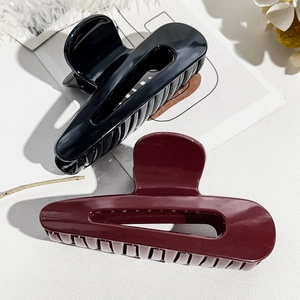 Dettaglio macro di pinze per capelli lucide marrone cioccolato e nere per capelli folti