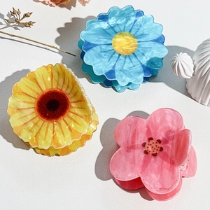 Detail of sunflower and daisy hair claws with marble texture in acetate material