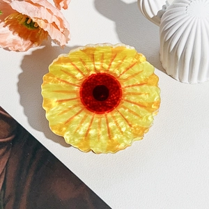 Detailed macro view of yellow sunflower hair claw clip with pearlescent acrylic finish