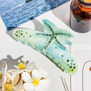 Macro detail of ocean starfish hair claw clip with mint green acetate and inlaid rhinestones