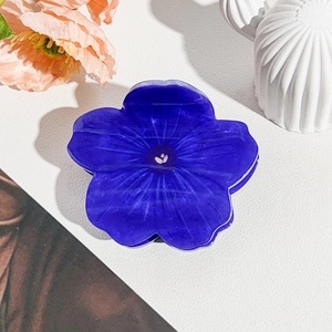 Close-up of a purple sunflower hair claw clip made of textured acrylic resin