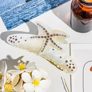 Close-up of pearl starfish hair claw with sparkling champagne rhinestones on a table