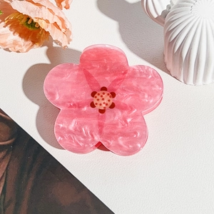 Detailed macro of pink marble acetate flower hair claw clip with petal textures