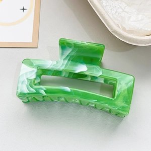 Macro shot of marble textured green and white acetate hair claw clip with cutout