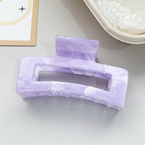 Detail view of a large rectangular hair claw clip with purple marble pattern texture