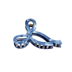 Elegant blue marble texture hair claw clip with gold spring on a plain white background