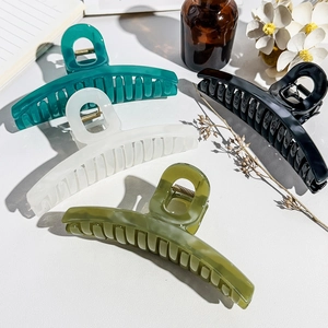 Détail d'un lot de quatre grandes pinces à cheveux en couleurs gelée verte et noire