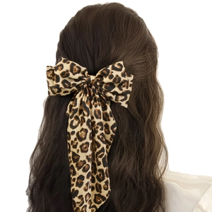 Leopard print bow hair clip with long ribbons on curly hair for vintage styling