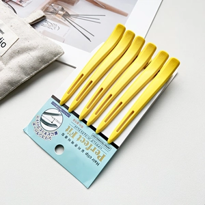 Detailsicht auf sechs gelbe Friseur-Haarklammern in der Originalverpackung