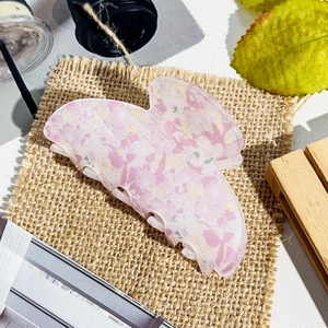 Detail of elegant acetate floral butterfly hair claw with marble texture and metal spring