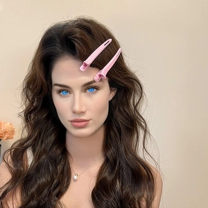 Friseur-Abteilclips in Rosa mit Perlenkette an einem weiblichen Model