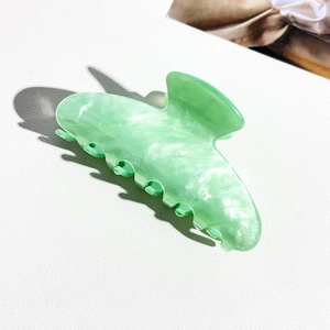 Detail view of large mint green acrylic hair claw clip with white marble pattern