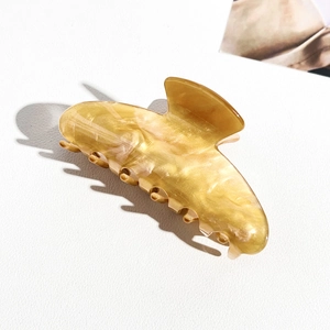 Detailed side view of large amber marble acrylic hair claw clip with smooth resin finish