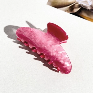 Detail of pink marble textured acrylic claw clip showing high-quality finish and teeth