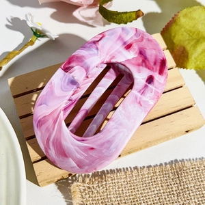 Detail showing the purple and white marble texture of the oval hair claw clip