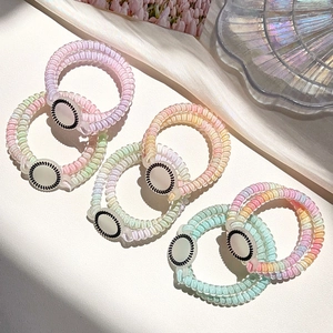 Detailed close-up of colorful spiral telephone wire hair ties with polka dot bead accents