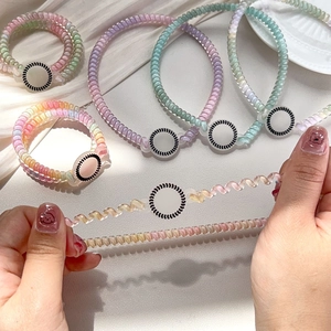 Macro shot of colorful gradient spiral hair ties showing high elasticity and stretch feature