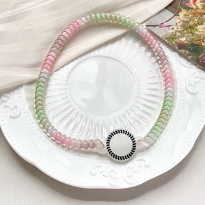 Detail of spiral hair ties with pearlescent finish on a decorative porcelain plate
