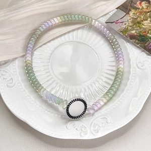 Detailed close-up of colorful spiral telephone wire bracelet with a polka dot pendant