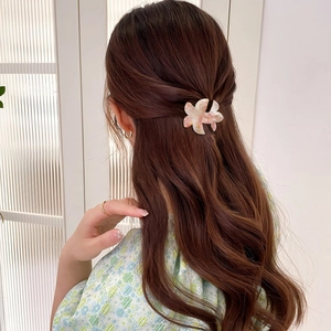 Pince à cheveux fleur en marbre rose sur modèle avec cheveux bruns et haut fleuri