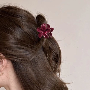 Pince à cheveux fleur de frangipanier rouge foncé sur modèle pour coiffure de vacances