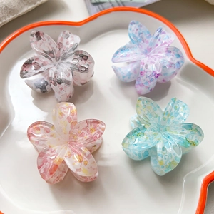 Vue détaillée de quatre pinces à cheveux fleurs en résine colorées avec motifs de marbre