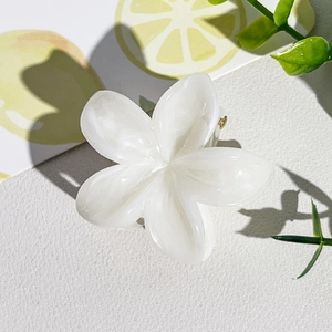 Détail de la pince à cheveux fleur frangipanier blanc crème avec éclat de nacre