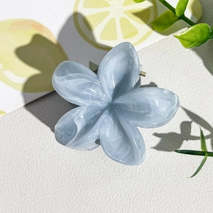 Détail de la pince à cheveux fleur en marbre bleu avec texture résine et style d'été
