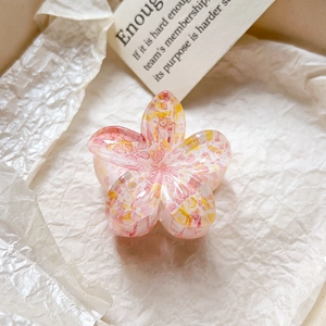 Détail de la pince à cheveux fleur avec texture éclaboussures rose jaune et fini résine