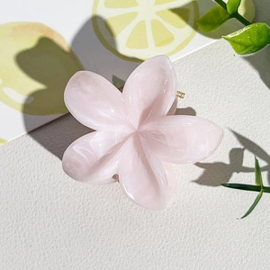 Détail d'une pince à cheveux fleur rose marbré avec ressort en métal doré
