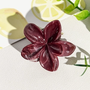 Vue détaillée d'une pince à cheveux fleur en acétate avec texture marbre violet