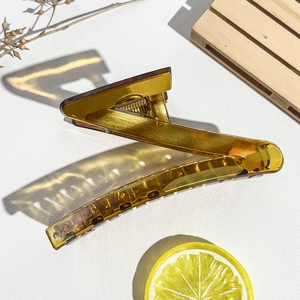 Détail d'une grande pince à cheveux ambre en zigzag avec finition acrylique translucide