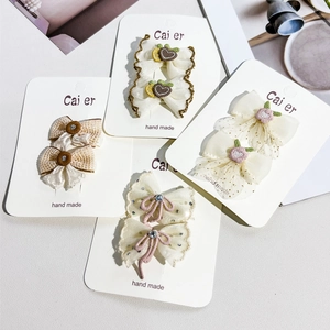 Détail de barrettes papillon en dentelle faites à la main avec broderies pour filles