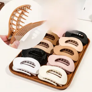 Detail view of large matte oval hair claw clips in Morandi colors and rounded teeth