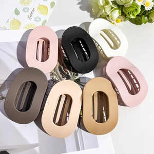 Matte finish oversized oval claw clips in seven neutral colors on a stylish lifestyle background