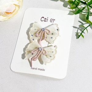 Détail de barrettes en dentelle avec cordon violet et cristal sur carte support