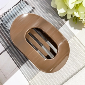 Detail view of large coffee brown oval hair claw clip with smooth glossy finish