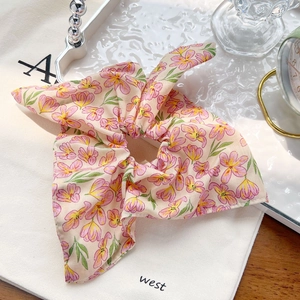 Vue détaillée du chouchou rose fleuri avec de longs rubans au style balletcore frais