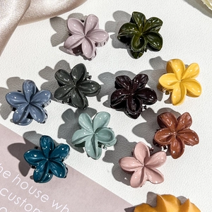 Close-up of 10 colorful 2.5cm frangipani flower hair claws with a glossy glitter finish