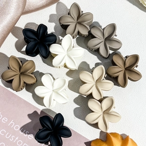 Detail view of 2.5cm matte frangipani flower hair clips in various Morandi colors